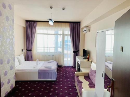 ein Hotelzimmer mit einem Bett und einem Fenster in der Unterkunft Resort Leon Beach in Mamaia Nord – Năvodari