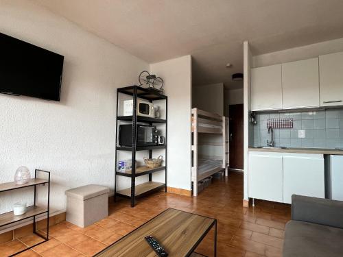 un salon avec un canapé et une table et une cuisine dans l'établissement Studio cabine avec parking privé et animaux admis à Sète - FR-1-338-622, à Sète