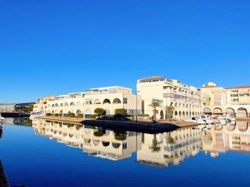 un groupe de bâtiments à côté d'une rivière dans l'établissement Studio cabine avec parking privé et animaux admis à Sète - FR-1-338-622, à Sète