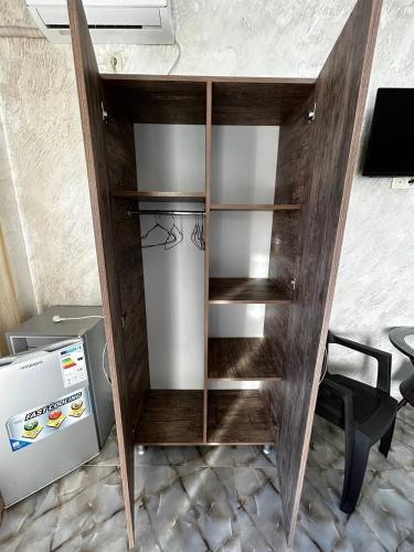 a wooden cabinet with a refrigerator in a room at Hotel Zhara in K'obulet'i