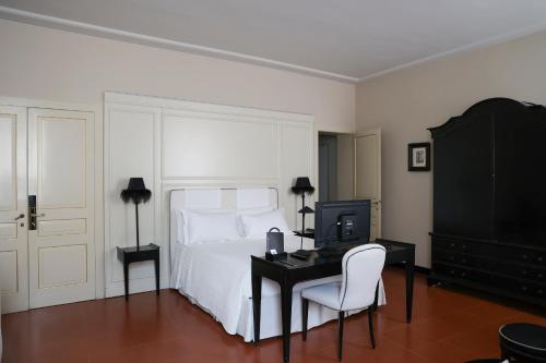 a bedroom with a bed and a desk with a computer at Santa Maria Foris in Ravenna
