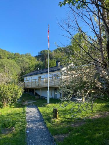 a white building with an american flag on a hill at Koselig hytte nær sandstrand in Langenes