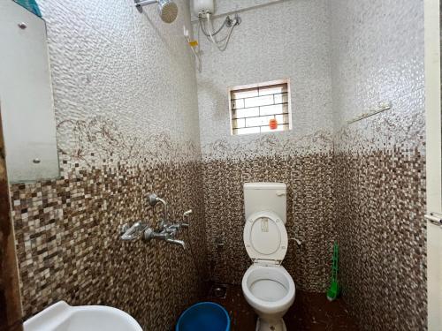 a bathroom with a toilet and a sink at Pihu Hotel in Calangute