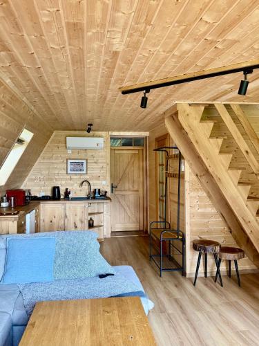 a living room with a blue couch and wooden ceilings at Domki Wierzchy in Wierzchy