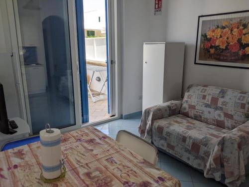 a living room with a couch and a table at Holiday Apartments Azzurro Salento in Torre Vado