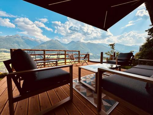 a balcony with chairs and a table and a view of mountains at Hochleiten-Gut in Niedernsill