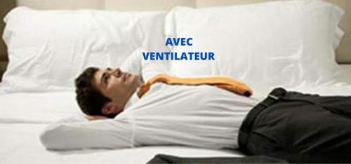 a man laying on a bed next to a pillow at Fast Hotel Colmar Houssen in Houssen