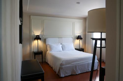 a bedroom with a white bed and two lamps at Santa Maria Foris in Ravenna