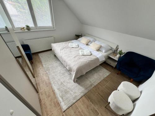 a small bedroom with a bed and a blue chair at Elysian apartment 1 in Trenčín