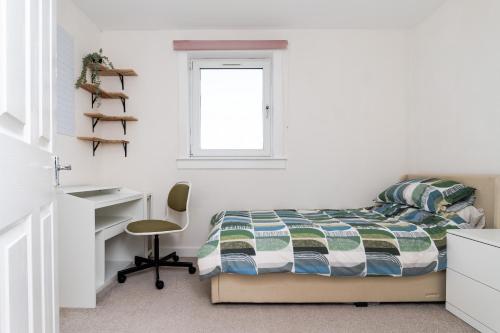 ピーブルスにある3 Bed House-Free Parkingのベッドと机と椅子のある寝室