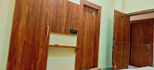 a room with a wooden cabinet and a closet at Abhiraj Guest House in Mathura