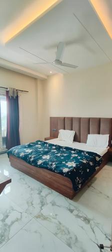 a bedroom with a bed with a blue comforter at Abhiraj Guest House in Mathura