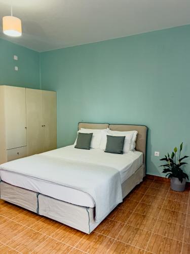 a large bed in a bedroom with blue walls at Live in Lemnos Studios in Moudhros