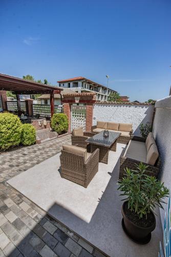 a patio with couches and a table and plants at Vila Amir Vama Veche in Vama Veche
