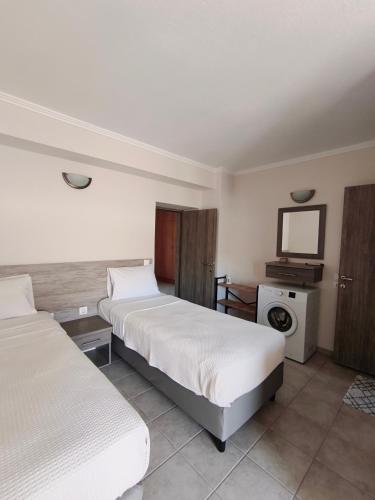 a hotel room with two beds and a tv at Daniela Apartments in Nea Roda