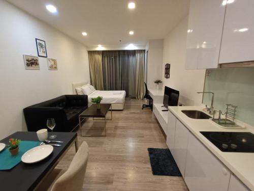 a kitchen and living room with a couch and a table at AK Residence in Kuala Lumpur