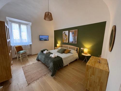 a bedroom with a bed and a green wall at Casa Vacanze La Donna di Cuori in Volterra