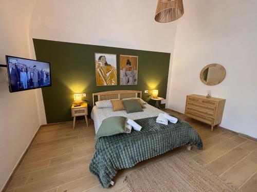 a bedroom with a bed with a green wall at Casa Vacanze La Donna di Cuori in Volterra