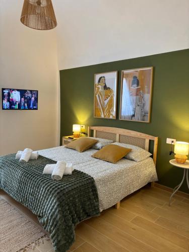 a bedroom with a large bed with three pictures on the wall at Casa Vacanze La Donna di Cuori in Volterra