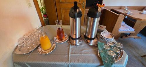 a table with two coffee makers and an orange juice at Pension Edi in Leutasch