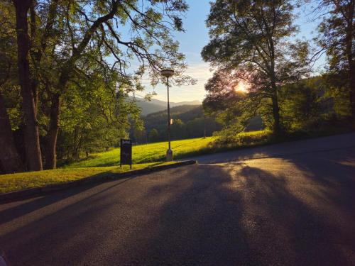an empty road with the sun setting in the distance at Penzion Pohádka in Hojsova Stráž