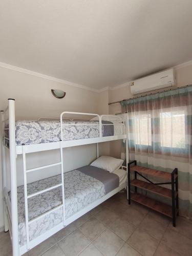 a bedroom with two bunk beds and a window at Daniela Apartments in Nea Roda