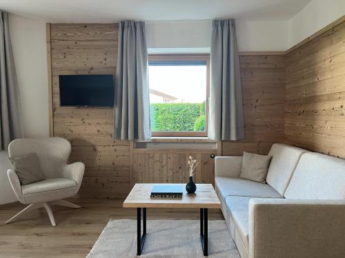 a living room with a couch and a chair and a table at Apartments Complojer in Reischach