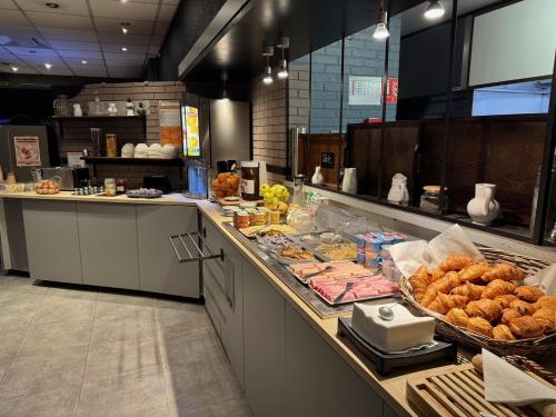 a kitchen with a counter with many different types of food at Comfort Hotel Orleans Saran in Saran