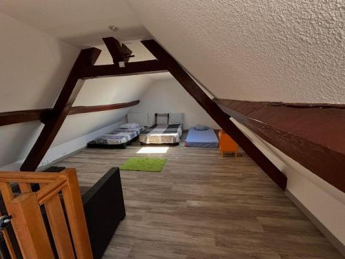 a attic room with three beds and a wooden floor at Chic et relax familial in Montmarault