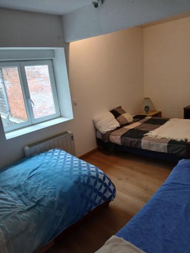 a bedroom with two beds and a window at Chic et relax familial in Montmarault