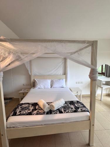 a bed with two pillows on top of it at Goldensun Resort Studio in Diani Beach