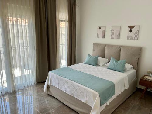 a bedroom with a large bed with blue pillows at Casa M- Studio #1 - Brand New in Herceg-Novi