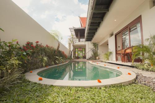 an exterior view of a house with a swimming pool at Rasa Ubud Yoga Coliving in Ubud