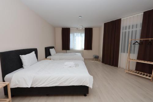 a bedroom with two beds with white sheets at Blue Life Hotel in Konak