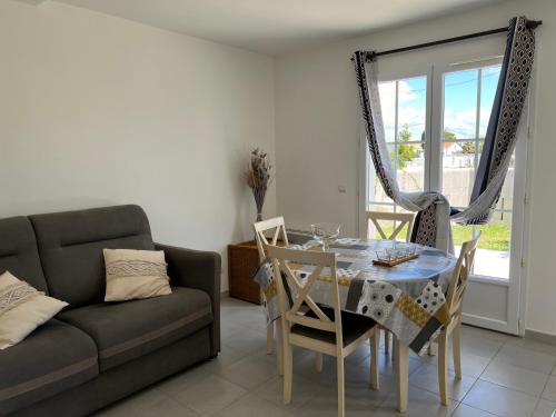 un salon avec une table et un canapé dans l'établissement Maison proche du pont de l ile d Oléron, au Château-dʼOléron