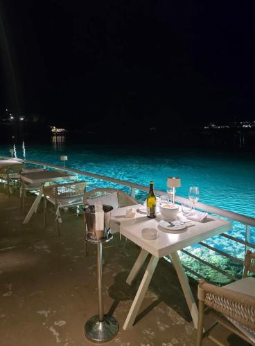a table with a bottle of wine next to the ocean at Thelfi Luxury studio in Attica - close to varkiza beach - Sea view in Vari