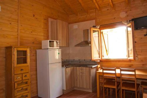 a kitchen with a white refrigerator and a window at Apartamentos Paraje San Gines in Andújar