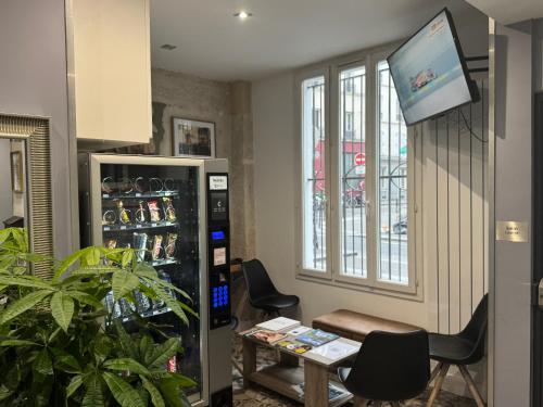 a room with a refrigerator and a table and chairs at Paris Rooms & Dreams Hotel in Paris