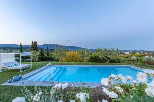 a swimming pool in a garden with white flowers at The Secret Escape Villa in Sant' Alessio
