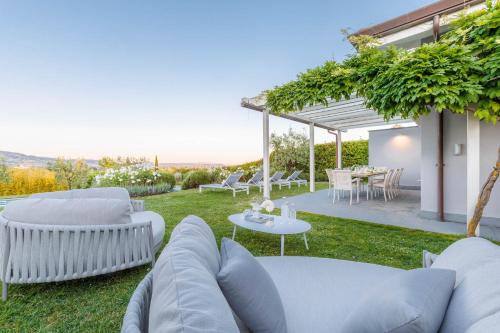a garden with white furniture and a table and chairs at The Secret Escape Villa in Sant' Alessio