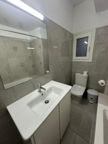 a bathroom with a white sink and a toilet at Mediterranean Blue - Secret Escape in Limassol