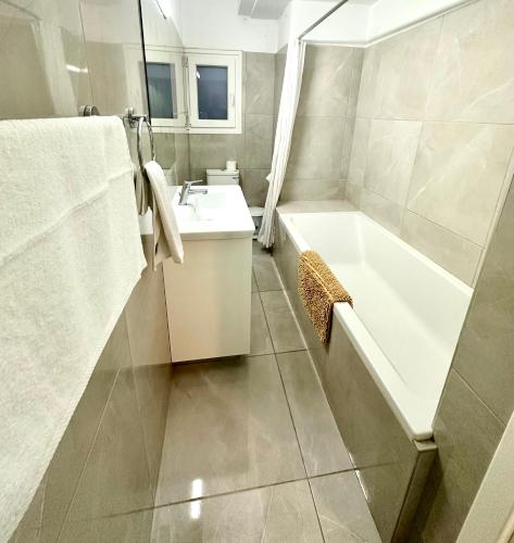a bathroom with a white tub and a sink at Mediterranean Blue - Secret Escape in Limassol