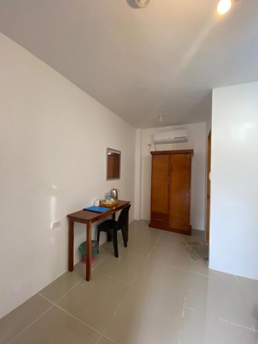 a room with a wooden table in a room at Coconut Inn Moalboal in Moalboal