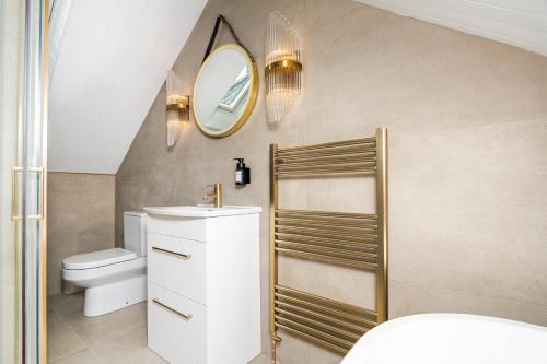 2 Bedroom Cottage-Free Parking في Newtongrange: حمام مع حوض و مرآة و مرحاض