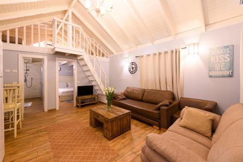 a living room with a couch and a loft at בקתות ילוז של רשת לב הגולן - 6 צימרים מקסימים עם בריכה משותפת ליד הכנרת in Yavneʼel