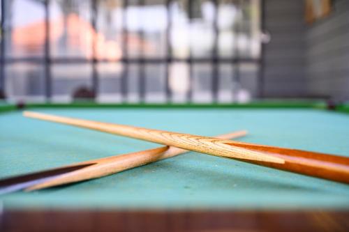 two cue sticks on top of a pool table at בקתות ילוז של רשת לב הגולן - 6 צימרים מקסימים עם בריכה משותפת ליד הכנרת in Yavneʼel