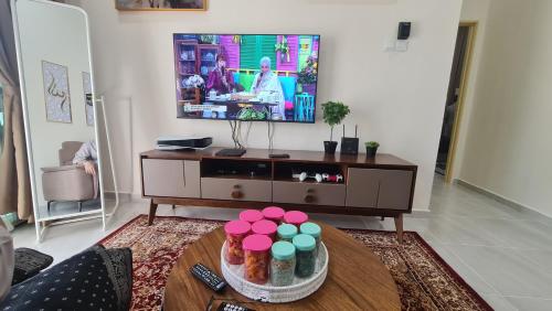 a living room with a tv and a table at Homestay cikgu Balia in Tanah Merah