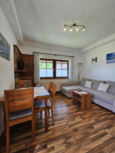 a living room with a table and a couch at Landhotel Lacknerhof in Mariapfarr
