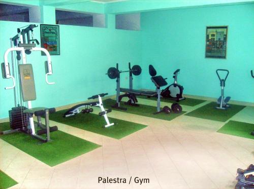 Hotel Residence Riviera Calabra في زامبروني: صالة ألعاب رياضية مع معدات ممارسة الرياضة في الجدار الأزرق