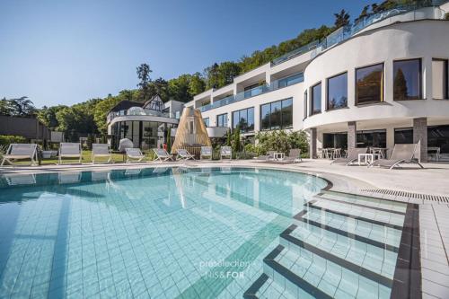 a large swimming pool in front of a building at 6717 Nature Hôtel & Spa Le Clos des Délices in Ottrott